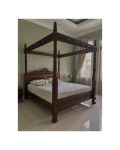 a wooden canopy bed in a room with at Ndalem Bu Fit Villa in Jakarta +9 photos