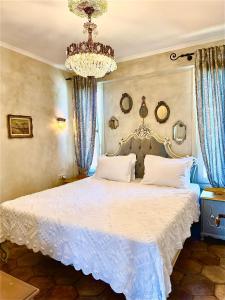a bedroom with a large white bed with a chandelier at ST NIKOLA PANORAMIC SUITES HALKIDIKI in Ayios Nikolaos Sithonia +68 photos