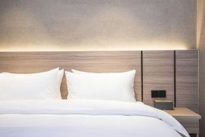 Postel nebo postele na pokoji v ubytování Sucha Hotel Shaowu