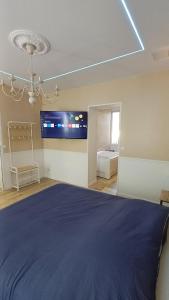 a bedroom with a large bed and a flat screen tv at T2 Cosy Spa & Sauna in Nesle