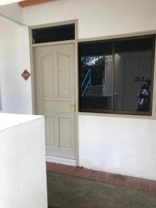 a building with a white door and a window at Seri Bulan Apartment in Kampong Tanah Merah