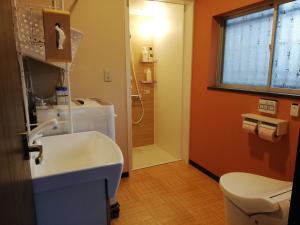 新宫市ゲストハウス みふね的带白色水槽和淋浴的浴室