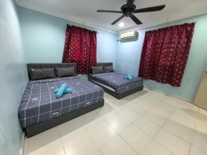 two beds in a room with red curtains at Lagenda Serai Wangi Homestay in Padang Serai