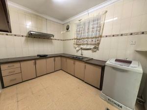 a small kitchen with a sink and a stove at Lagenda Serai Wangi Homestay in Padang Serai +22 photos