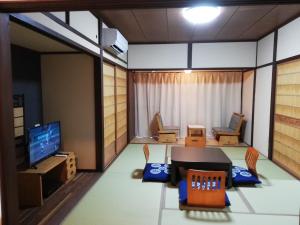 新宫市ゲストハウス みふね的有桌椅和电视的房间
