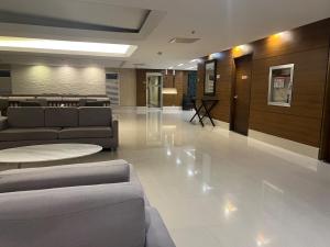 Un vestíbulo con sofás y mesas en un edificio. en Near World Trade, Star City and MoA - Amazing Breeze, en Manila