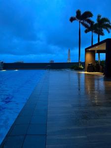 Una piscina con palmeras y un edificio. en Near World Trade, Star City and MoA - Amazing Breeze, en Manila