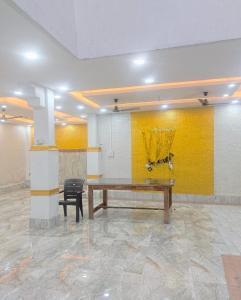 a room with a wooden table and a yellow wall at Comfi Stay Hotel Bhopal in Bhopal
