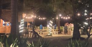 un gruppo di persone che si trovano intorno a un tavolo con luci di Hotel Coral Bay a Trincomalee Altre 37 foto