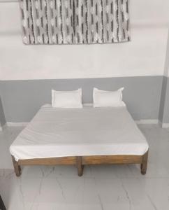 a bed with two pillows on it in a room at Comfi Stay Hotel Bhopal in Bhopal +13 photos