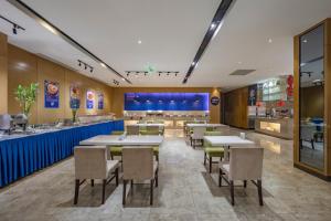 Un restaurante con mesas y sillas y un mostrador. en Holiday Inn Express Shanghai New Jinqiao by IHG, en Shanghái