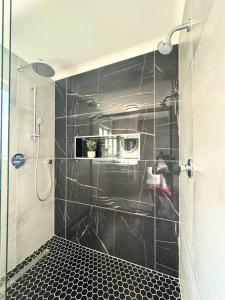 a bathroom with a shower with a glass door at El Mufasa beachfront apartment with stunning views in Cape Town