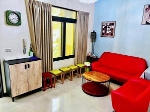 a living room with a red couch and chairs at 時光旅舍 in Jincheng +24 photos