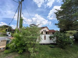 a house with a pole in the yard at Lagenda Serai Wangi Homestay in Padang Serai