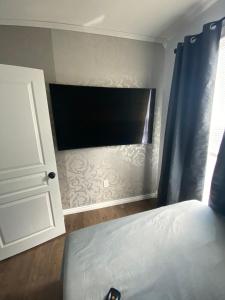 a bedroom with a bed and a flat screen tv at Luxury apartment near Old Orchard Beach in Biddeford +6 photos