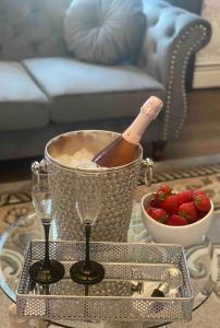 a table with a bowl of strawberries and a bucket of wine at Luxury apartment near Old Orchard Beach in Biddeford