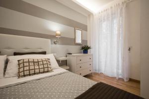 a bedroom with a bed and a dresser and a window at Saint Peter Apartment in Rome