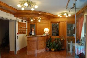 a woman standing at a counter in a room at Hotel Milano in Asiago