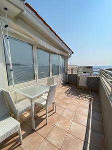 un patio con tavolo e sedie su un balcone di Casa Maria a Santa Maria al Bagno