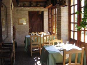 a room with tables and chairs and a door at Cabanias El Aguaribay in San Javier