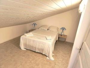 a bedroom with a white bed in a attic at -Belle vue-Villa duplex-AC-jardin-parking in Alignan-du-Vent +65 photos