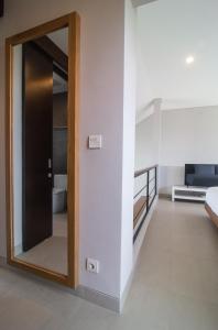 a room with a mirror and a bed in a room at Grace Villa in Tanah Lot