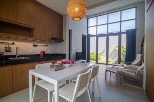 a kitchen and dining room with a white table and chairs at Grace Villa in Tanah Lot
