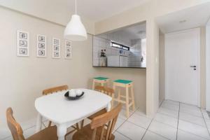 - une salle à manger blanche avec une table et des chaises blanches dans l'établissement Apartamento Em Boa Viagem!, à Récife