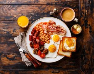 a plate of breakfast food with eggs bacon beans and toast at Hotel RK ICON in Ahmedabad