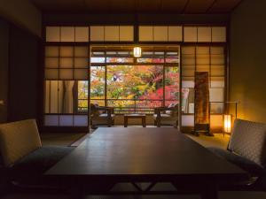 una camera con tavolo, sedie e finestra di Hashinoya Bekkan Ransui a Kobe