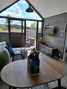 a living room with a table and a tv at Domki Wilków z widokiem na Łysicę in Wilków