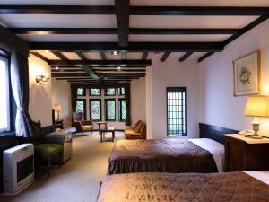 a bedroom with two beds and a living room at Petit Hotel & Restaurant Old Age in Hokuto +105 photos