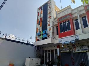 un bâtiment avec une enseigne sur le côté dans l'établissement Front One Budget Hotel Tirtonadi Solo, à Solo