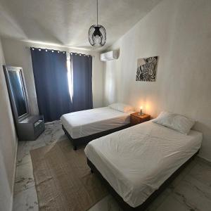 a bedroom with two beds and a window with a lamp at Casa Marina, Playa y Aeropuerto cerca in Puerto Vallarta +33 photos