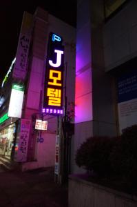 a building with a neon sign on the side of it at J Motel Gwangalli Busan in Busan