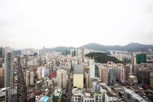 eine große Stadt mit Gebäuden und Bergen im Hintergrund in der Unterkunft Le Prabelle Hotel in Hongkong