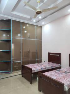 a bedroom with two beds and a large closet at Al-Jannat Girls Hostel in Lahore