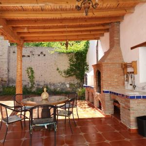 a patio with a table and chairs and a brick oven at Casa Orquídea con Alberca en Centro Histórico in Parras de la Fuente