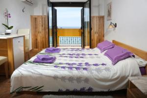 1 dormitorio con 1 cama grande con almohadas moradas en Rooms Figarola, en Rovinj