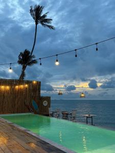 ein Swimmingpool mit Blick auf das Meer in der Unterkunft Natural Wing Health Spa and Resort in Ban Bang Po