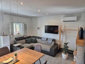 a living room with a couch and a table at Olive Grove House Lumbarda in Lumbarda