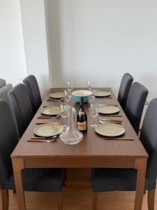 a wooden table with plates and wine glasses on it at Apartamento LUZ DA PRAIA in Vila Chã