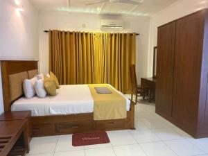 科伦坡Urban Deck的一间卧室配有一张黄色窗帘的床