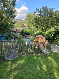 two chairs sitting in the grass near a fence at La Borda de Ritort in Sort +11 photos
