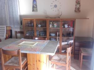 a kitchen with a table and chairs and a clock on the wall at Appartamento Arenella in Arenella