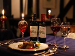 a table with two bottles of wine and a plate of food at Petit Hotel & Restaurant Old Age in Hokuto