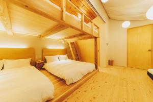 a bedroom with two beds and a loft at moon river in Hatsukaichi