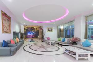 a living room with couches and a pink ceiling at Nana Chat Bangsaen Hotel in Ban Thai Don (1)