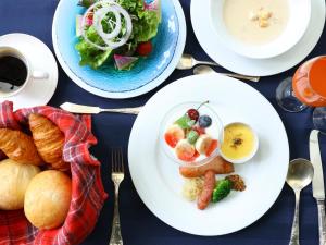 a table with plates of breakfast foods and a cup of coffee at Petit Hotel & Restaurant Old Age in Hokuto