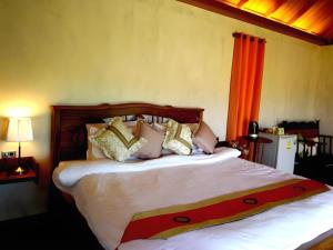 a bedroom with a bed with white sheets and pillows at Pripta Boutique Resort in Pai